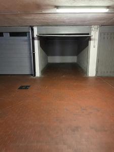an empty parking garage with two garage doors and a brick floor at Como Lake - Balcony, Private Parking, 2 Bathrooms in Cernobbio