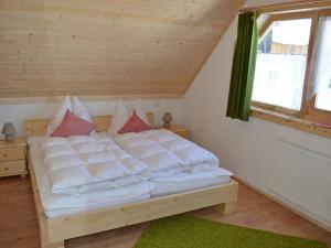 a bedroom with a bed with white pillows and a window at "kleines jagdhaus"- Hüttenurlaub in Bayern in Philippsreut