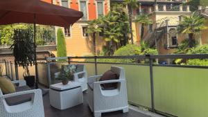 a balcony with chairs and an umbrella and some buildings at Como Lake - Balcony, Private Parking, 2 Bathrooms in Cernobbio