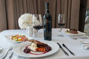 The Mount Knysna في كنيسنا: طاولة مع طبق من الطعام وزجاجة من النبيذ