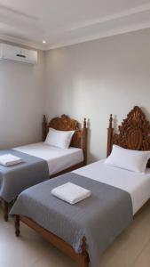 two beds sitting next to each other in a room at Pousada Emanuel in Paracatu