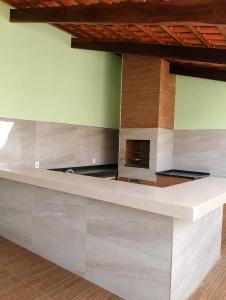 a kitchen with a stone counter with a fireplace at Pousada Emanuel in Paracatu