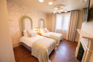 two beds in a room with two mirrors at The Carre Arms Hotel & Restaurant in Sleaford