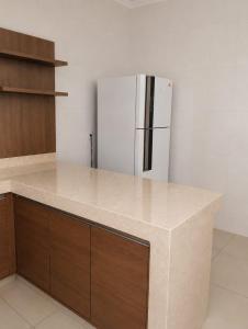 a kitchen with a white refrigerator and wooden cabinets at Pousada Emanuel in Paracatu +12 photos