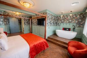 a bedroom with a tub and a bed and a fireplace at The Carre Arms Hotel & Restaurant in Sleaford