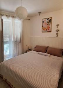 a bedroom with a large bed and a window at Apartment Zlatko in Šibenik