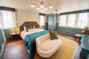 a bedroom with a bed and a couch and windows at The Carre Arms Hotel & Restaurant in Sleaford
