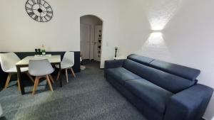 a living room with a blue couch and a table at Ferienwohnung Kamerer in Bad Harzburg