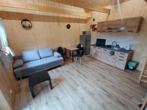 a living room with a couch and a kitchen at Domki Marianowo in Marianowo