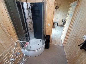 a bathroom with a shower and a bath tub at Domki Marianowo in Marianowo +17 photos