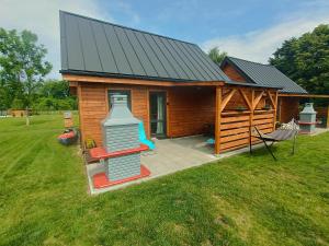 a large wooden cabin with a patio and a house at Domki Marianowo in Marianowo