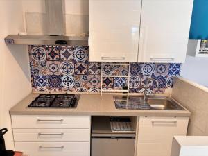 a kitchen with white cabinets and a sink and tiles at casa villa degli ulivi in Colonnella