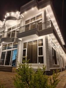 a large white building with a balcony at night at Uforia Munnar in Munnar