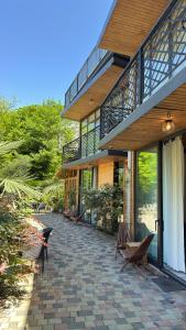 a building with a patio with benches in front of it at Chalet Kvariati in Kvariat'i