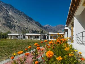 a garden of orange flowers in front of a building at Arhat Resort in Deskit