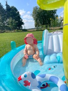 a baby sitting in a pool in a water slide at Haus Mediterran in Kamień Pomorski