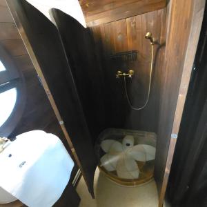 a small bathroom with a toilet with a shower at Várlak Glamping in Sub Cetate