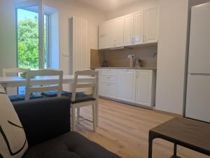 a kitchen with white cabinets and a table and chairs at Apartmány v Propadání in Jedovnice +43 photos