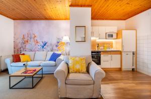 a living room with two couches and a kitchen at Haus Elisabeth, Appartements in Krumpendorf am Wörthersee