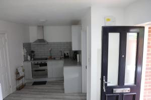 a kitchen with white appliances and a door open at Comfy Guest suite in Dartford