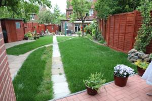 a yard with green grass and potted plants at Comfy Guest suite in Dartford +5 photos