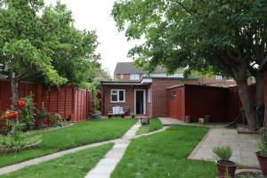 a backyard of a house with a grass yard at Comfy Guest suite in Dartford