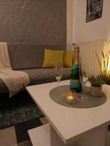 a table with two wine glasses and a bottle on it at Boróka Panzió in Parád