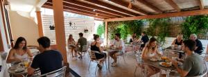 a group of people sitting at tables in a restaurant at Hotel le Sabbie in Calasetta