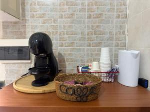 a kitchen counter with a coffee maker and a basket of cups at La Dimora di Zia Rosa in Crotone