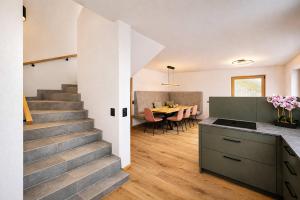 a kitchen and dining room with a staircase in a house at SKYLINE Chalet - Two-Level Penthouse with Private Whirlpool in Mühlen