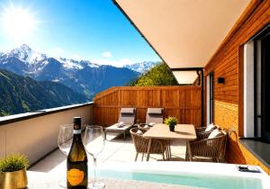 a balcony with a table and chairs and a bottle of wine at SKYLINE Chalet - Two-Level Penthouse with Private Whirlpool in Mühlen