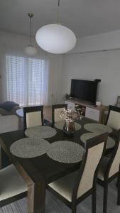 ein Esszimmer mit einem schwarzen Tisch und Stühlen in der Unterkunft Apartman Anđa in Široki Brijeg