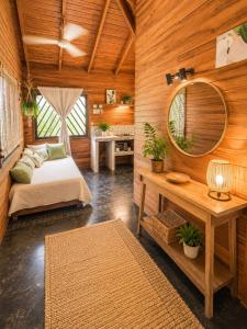 a bedroom with a bed and a mirror and a table at Anam Apartments in Santa Teresa Beach