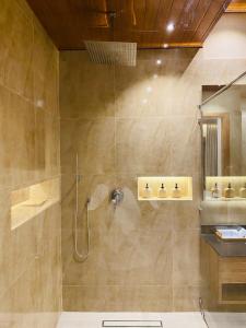 a bathroom with a shower with a glass door at Beach Escape in Arugam Bay +58 photos