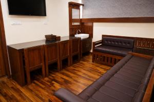 a court room with a bench and a sink and a television at Nova North Inn in Cochin