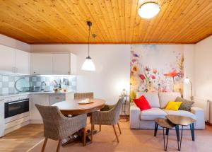 a kitchen and living room with a table and a couch at Haus Elisabeth, Appartements in Krumpendorf am Wörthersee +40 photos