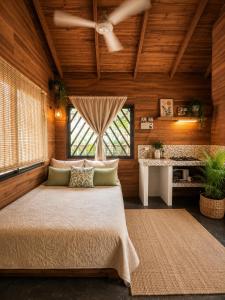 a bedroom with a bed and a ceiling fan at Anam Apartments in Santa Teresa Beach
