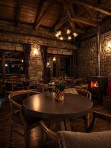 a dining room with a table and chairs and a fireplace at Village Inn in Ano Chora +36 photos