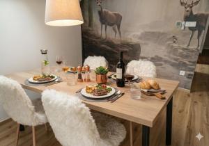 a wooden table with plates of food and wine at Residence Marianka in Albrechtice v Jizerských horách