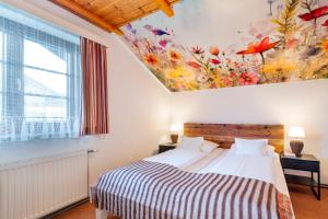a bedroom with a bed with a flower painting on the wall at Haus Elisabeth, Appartements in Krumpendorf am Wörthersee