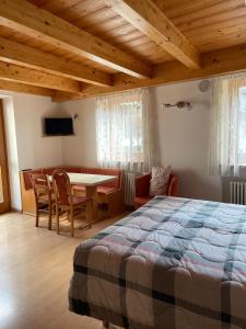ein Schlafzimmer mit einem Bett, einem Tisch und Stühlen in der Unterkunft Alpina depandance in Castello Tesino