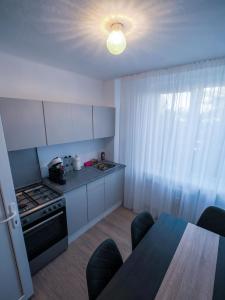 a small kitchen with a table and a stove at Shakespeare Central Apartment in Craiova