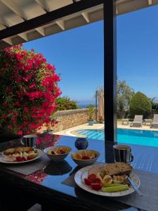 a table topped with plates of food next to a pool at Hillside Villa with Sea Views in Kyrenia