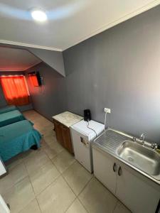 a kitchen with a sink and a bed in a room at Hostal JV CASA AMPLIA in Nogales +37 photos