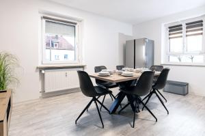 a dining room with a table and chairs and a refrigerator at Casa Materi Schweinfurt in Schweinfurt
