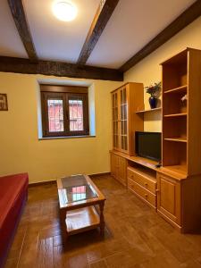 a living room with a couch and a tv at Rincón de Laciana in Caboalles de Abajo