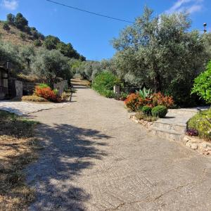 a garden with flowers and trees and a pathway at Cortijo La Joya in Lanjarón +2 photos