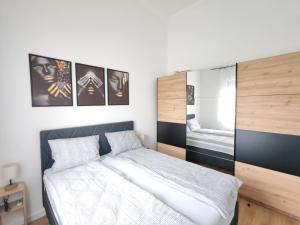 a bedroom with a bed and pictures on the wall at Apartman Petkov in Palić
