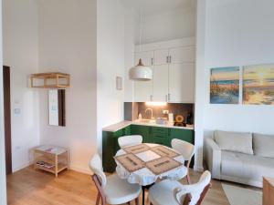 a kitchen and living room with a table and chairs at Apartman Petkov in Palić