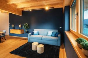 a living room with a blue couch and two stools at GLETSCHERBLICKSTUBE - Terrace & Mountain View in Fügen